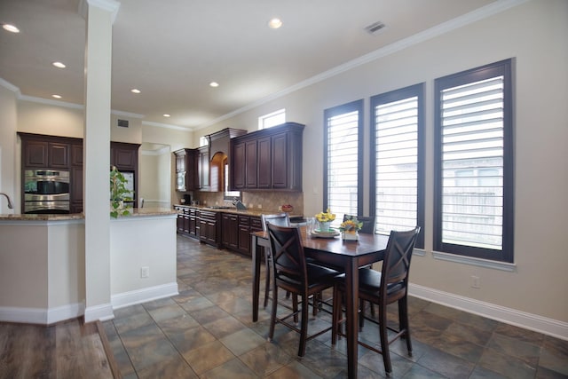 dining room featuring ornamental molding and sink