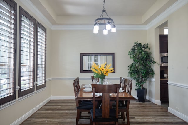 dining space featuring dark hardwood / wood-style floors, a wealth of natural light, and crown molding