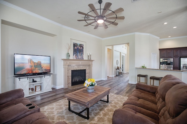 living room with dark hardwood / wood-style floors, ceiling fan, and crown molding