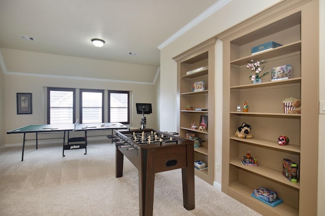 recreation room with built in shelves, light colored carpet, and ornamental molding