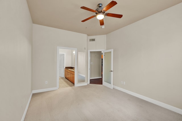 unfurnished bedroom with light colored carpet, ceiling fan, and ensuite bathroom