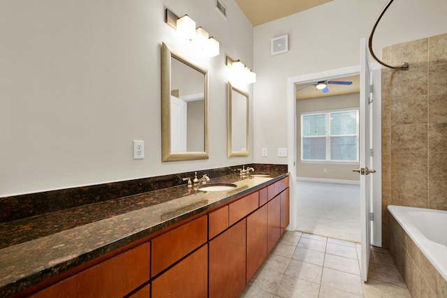 bathroom with vanity, ceiling fan, tile patterned floors, and tiled shower / bath combo