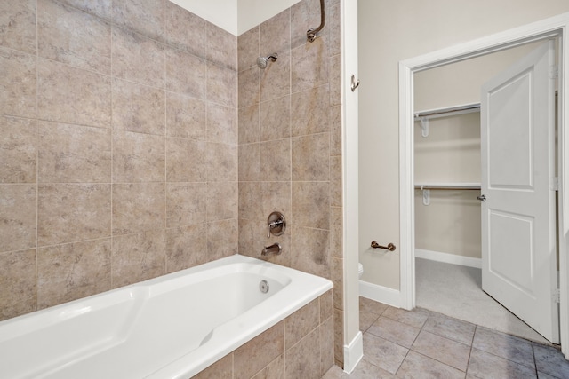 bathroom featuring toilet, tiled shower / bath, and tile patterned flooring