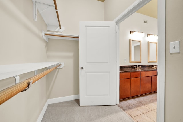 spacious closet featuring light colored carpet