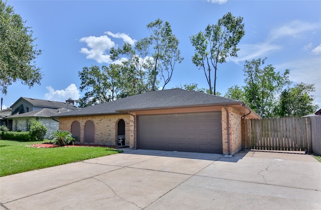 ranch-style home with a garage and a front yard