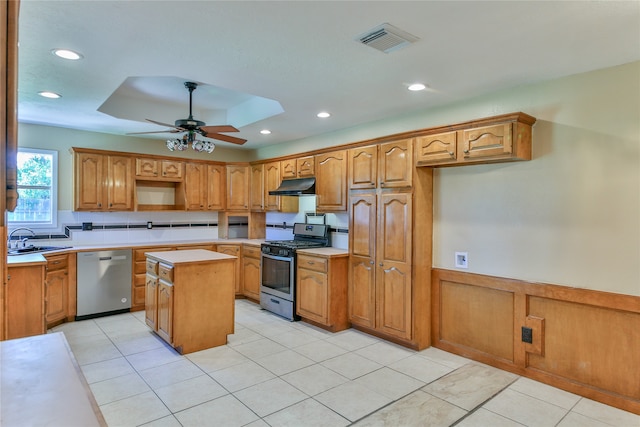 kitchen with a center island, light tile patterned floors, sink, ceiling fan, and appliances with stainless steel finishes