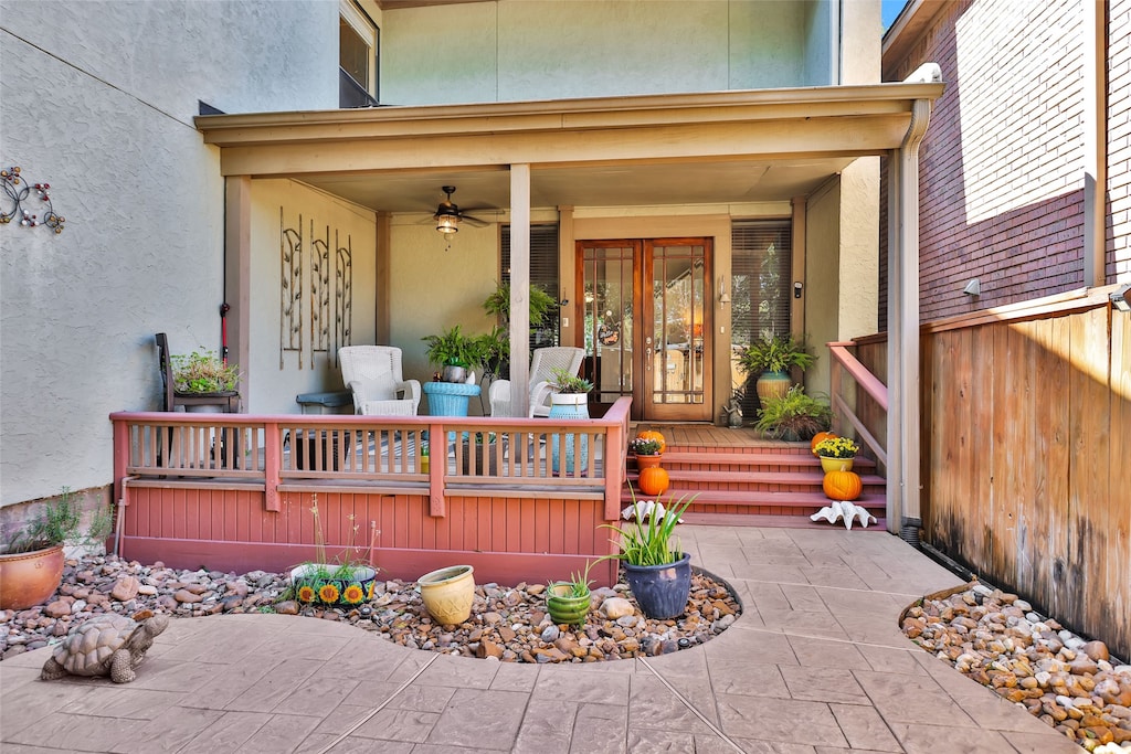 entrance to property with covered porch and ceiling fan