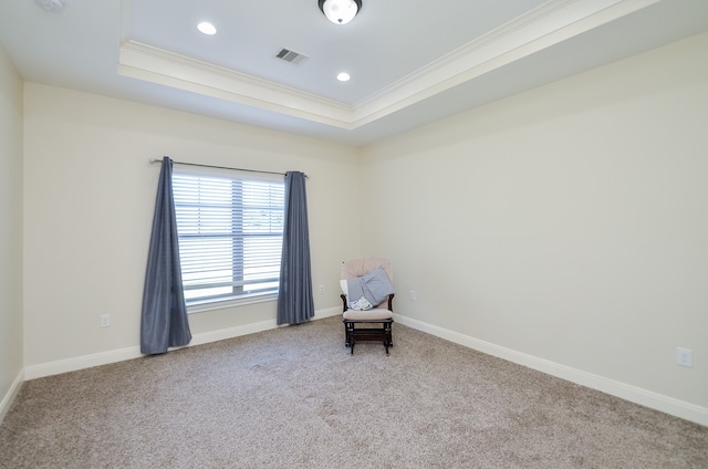 unfurnished room with a raised ceiling, crown molding, and carpet flooring