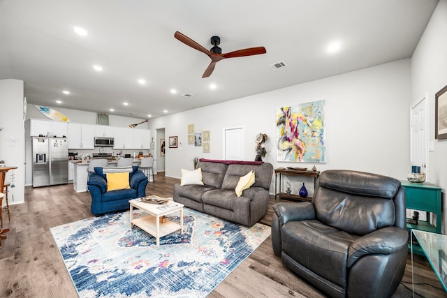 living room with light hardwood / wood-style floors and ceiling fan