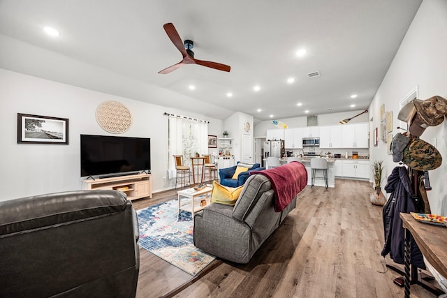 living room featuring ceiling fan and light hardwood / wood-style floors