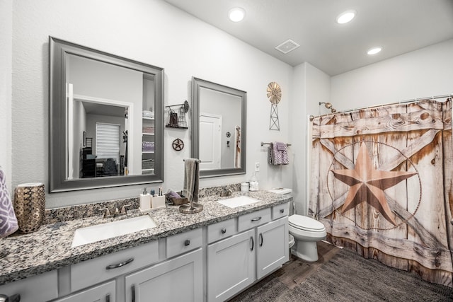 bathroom with toilet, a shower with curtain, vanity, and wood-type flooring