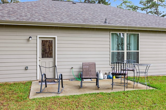 rear view of house with a lawn and a patio