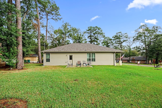 rear view of house featuring a lawn