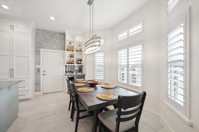 dining space with light hardwood / wood-style floors and a chandelier