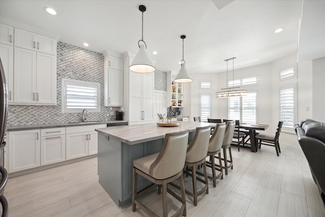 kitchen with a center island, plenty of natural light, hanging light fixtures, and a breakfast bar area