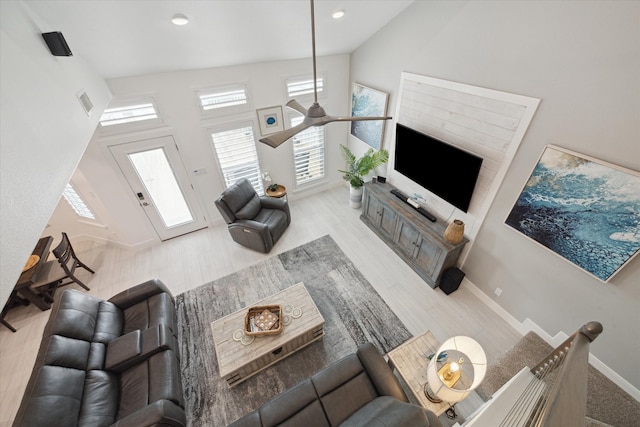 living room with ceiling fan, high vaulted ceiling, and light hardwood / wood-style floors