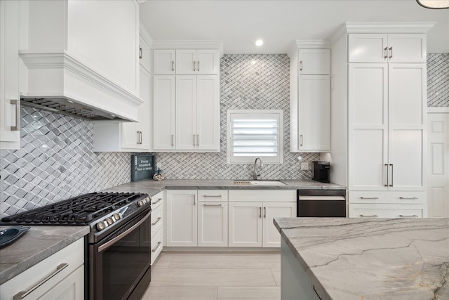 kitchen with sink, light stone counters, white cabinetry, and black appliances