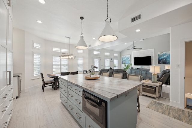 kitchen with plenty of natural light, white cabinetry, a center island, and decorative light fixtures