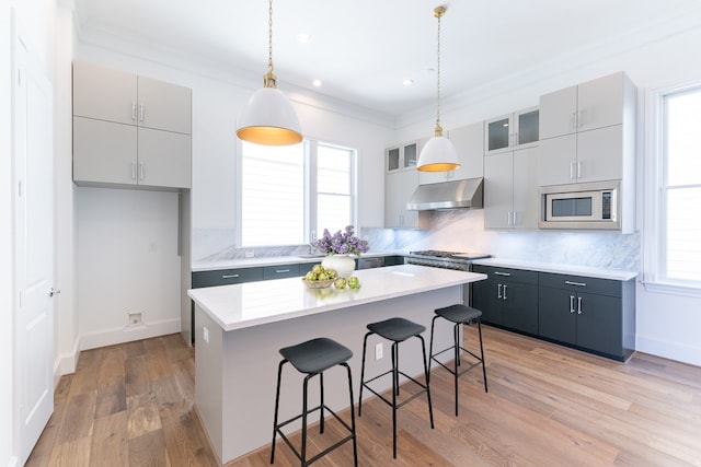 kitchen featuring plenty of natural light, a kitchen island, a kitchen bar, and stainless steel appliances