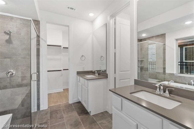 bathroom featuring a shower with door, vanity, and tile patterned flooring