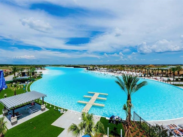 view of swimming pool featuring a water view and a yard