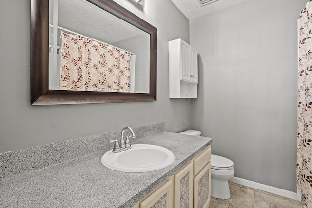 bathroom with vanity, tile patterned floors, toilet, and a textured ceiling