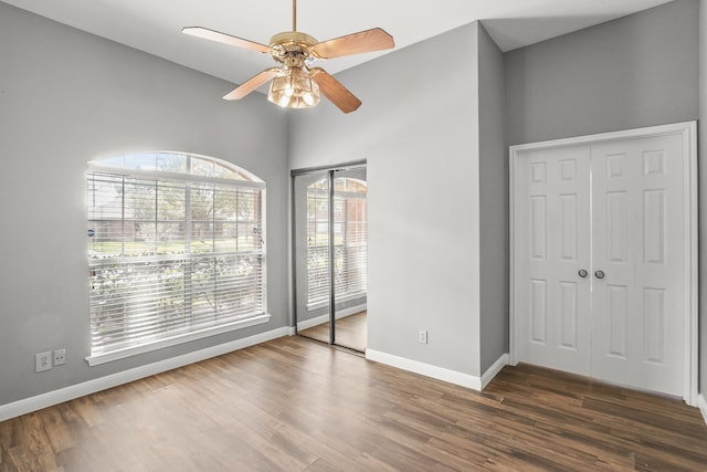 unfurnished bedroom with dark hardwood / wood-style flooring, multiple windows, and ceiling fan