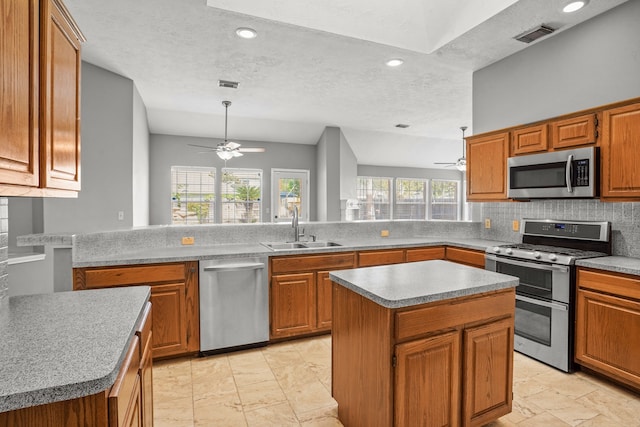 kitchen with kitchen peninsula, appliances with stainless steel finishes, and a kitchen island