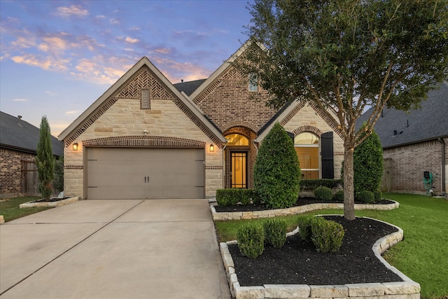 french country style house with a lawn and a garage