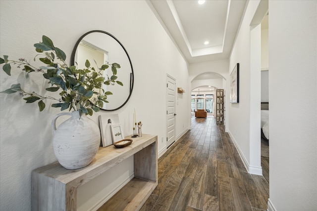 hallway featuring dark hardwood / wood-style flooring and a tray ceiling