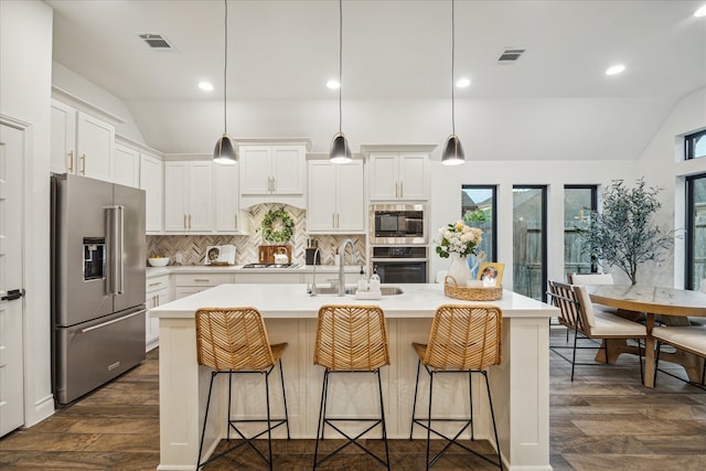 kitchen featuring stainless steel appliances, plenty of natural light, and lofted ceiling