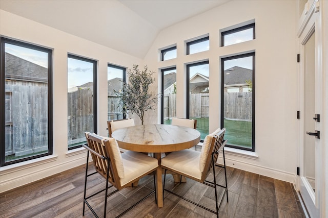 dining space with dark hardwood / wood-style flooring and lofted ceiling