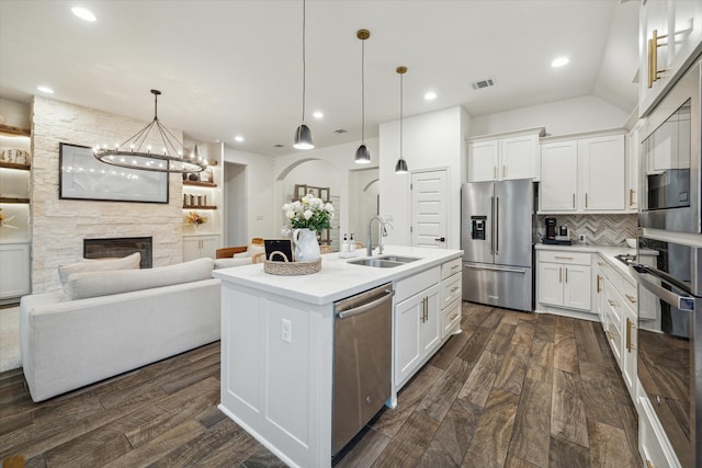 kitchen with white cabinetry, appliances with stainless steel finishes, sink, and an island with sink