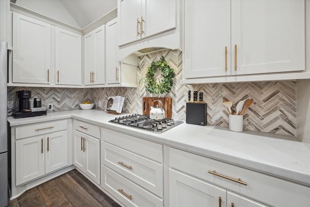 kitchen with stainless steel gas cooktop, light stone counters, tasteful backsplash, white cabinets, and dark wood-type flooring