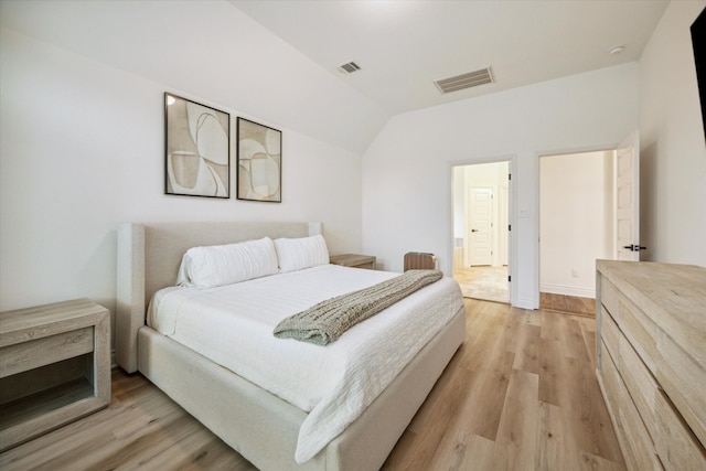 bedroom featuring light wood-type flooring and vaulted ceiling