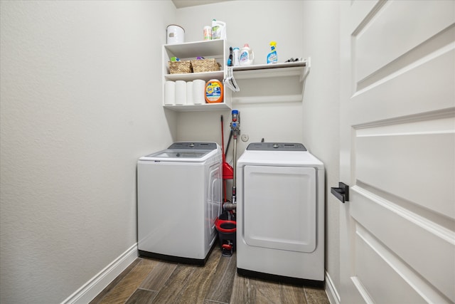 clothes washing area featuring washer and clothes dryer and dark hardwood / wood-style flooring