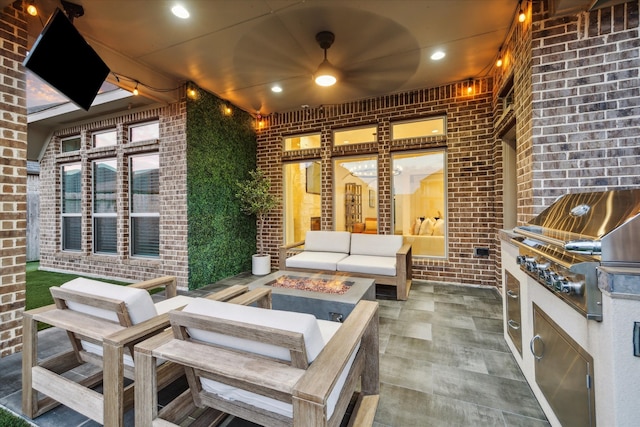 view of patio / terrace featuring an outdoor living space with a fire pit, an outdoor kitchen, and ceiling fan