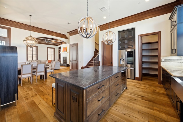 kitchen featuring stainless steel fridge with ice dispenser, a center island, light hardwood / wood-style flooring, and hanging light fixtures