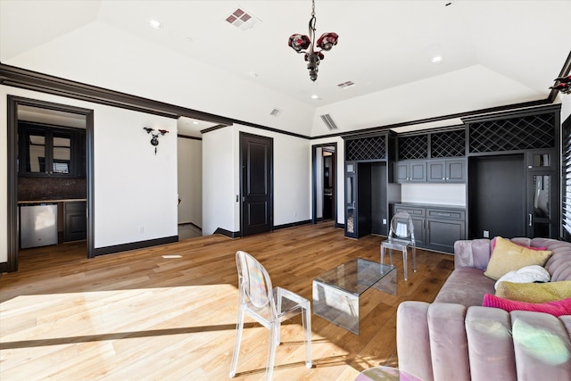 living room with hardwood / wood-style flooring, lofted ceiling, and a notable chandelier