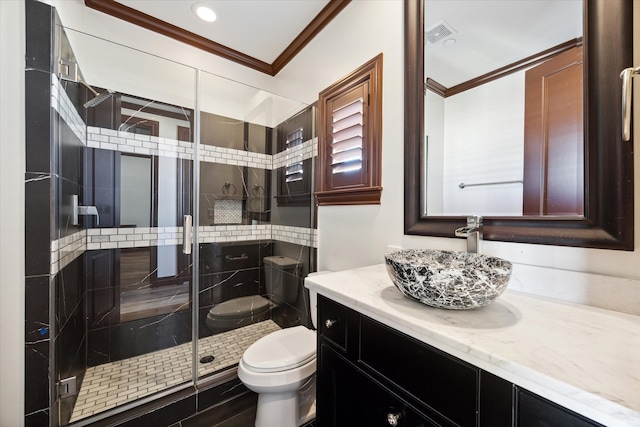 bathroom with a shower with door, vanity, ornamental molding, and toilet