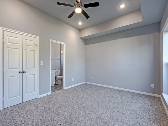 unfurnished bedroom featuring ceiling fan, connected bathroom, carpet flooring, and a closet