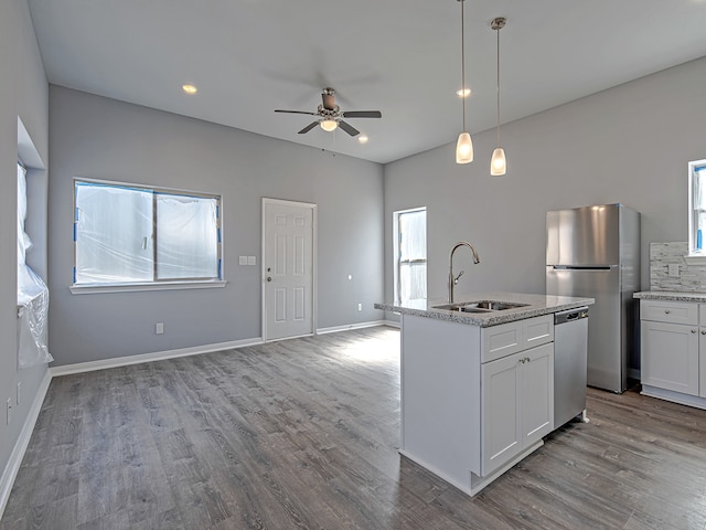 kitchen with stainless steel appliances, wood-type flooring, white cabinetry, and sink