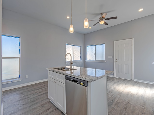 kitchen with light stone counters, white cabinetry, light wood-type flooring, sink, and dishwasher