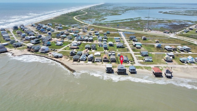 birds eye view of property with a water view and a beach view