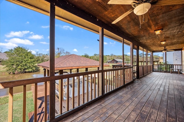 wooden deck featuring a water view and ceiling fan