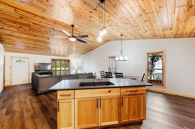 kitchen with ceiling fan with notable chandelier, lofted ceiling, sink, an island with sink, and dark hardwood / wood-style floors