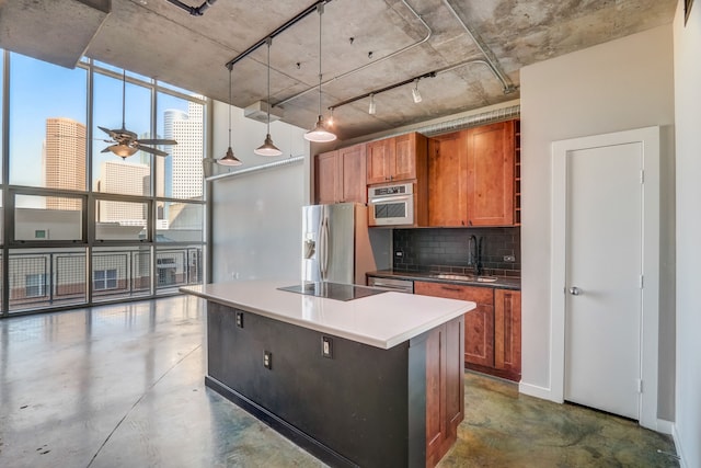 kitchen with stainless steel appliances, sink, tasteful backsplash, an island with sink, and decorative light fixtures