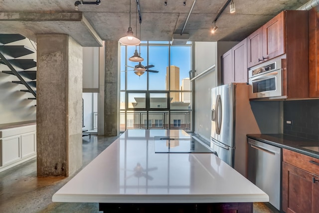 kitchen with stainless steel appliances, ceiling fan, decorative light fixtures, and decorative backsplash