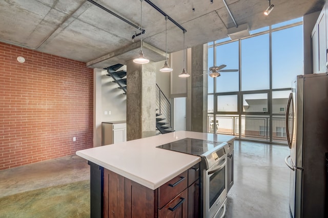 kitchen with stainless steel appliances, ceiling fan, a wall of windows, decorative light fixtures, and a center island