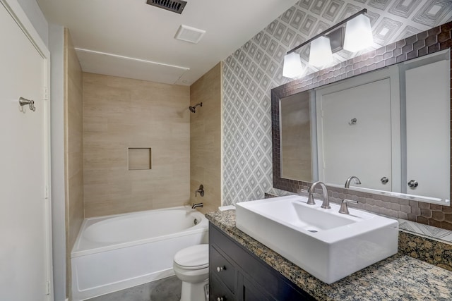 full bathroom featuring toilet, tile walls, decorative backsplash, tiled shower / bath, and vanity